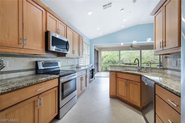 kitchen with backsplash, stainless steel appliances, light tile floors, dark stone countertops, and lofted ceiling