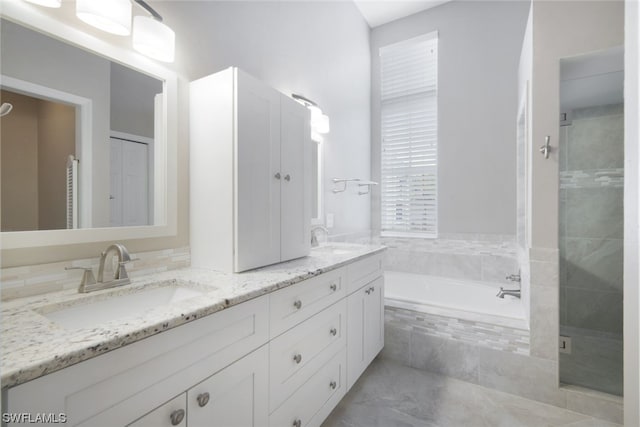 bathroom with dual bowl vanity, shower with separate bathtub, and tile flooring