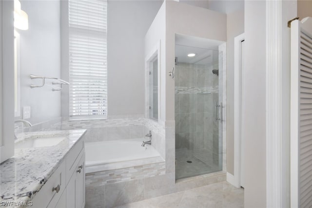 bathroom with shower with separate bathtub, vanity, and tile flooring