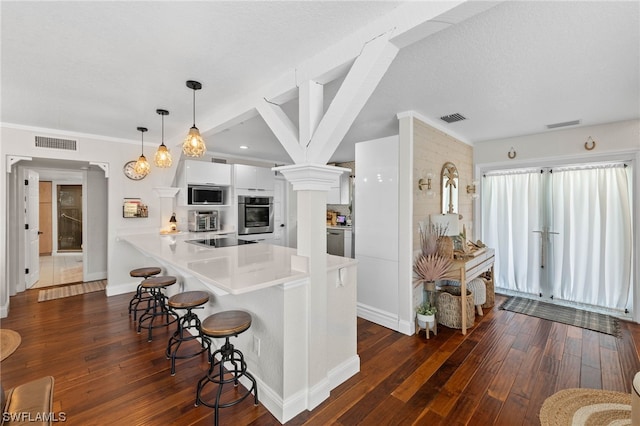 kitchen featuring white cabinetry, hanging light fixtures, appliances with stainless steel finishes, and dark wood-type flooring