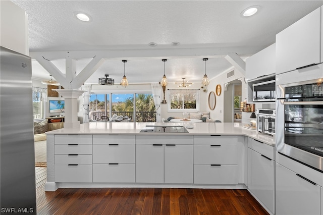 kitchen with pendant lighting, black electric stovetop, stainless steel refrigerator, and white cabinets