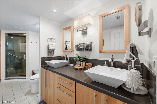 bathroom with tile patterned floors, vanity, toilet, and a textured ceiling