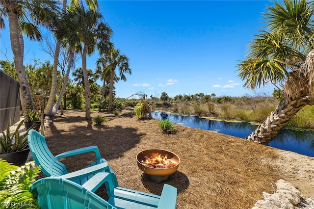 view of yard with a water view and a fire pit