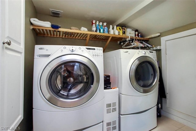 washroom with washing machine and dryer and light tile patterned flooring