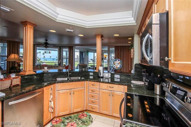 kitchen featuring decorative columns, a raised ceiling, sink, and appliances with stainless steel finishes