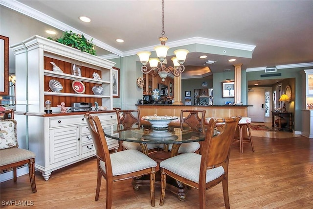 dining room featuring light hardwood / wood-style flooring, crown molding, and an inviting chandelier