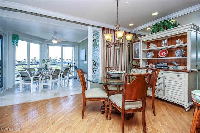 dining area with ceiling fan with notable chandelier, light hardwood / wood-style floors, and crown molding