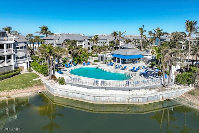 view of community with a swimming pool and a water view