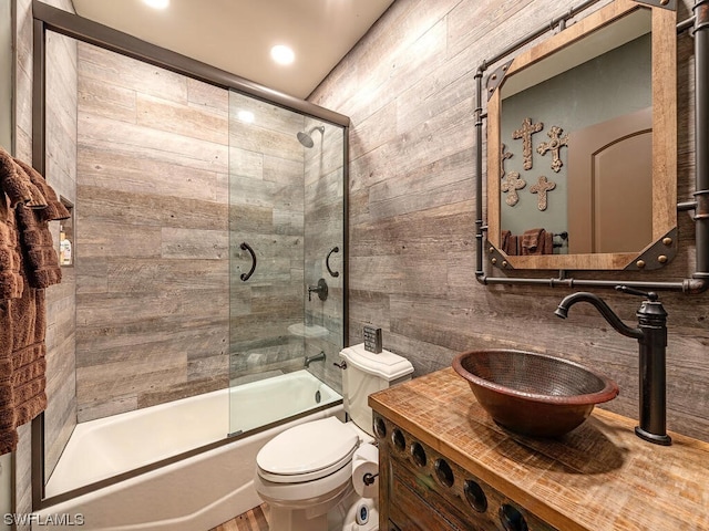 full bathroom featuring vanity, combined bath / shower with glass door, and toilet