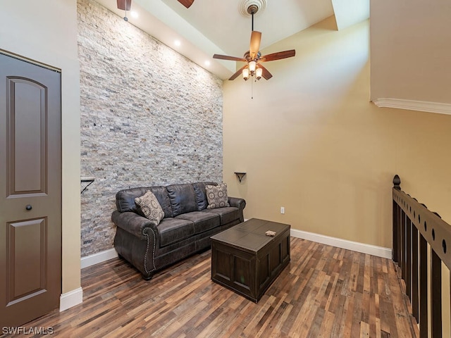 living room featuring ceiling fan, hardwood / wood-style floors, and a high ceiling