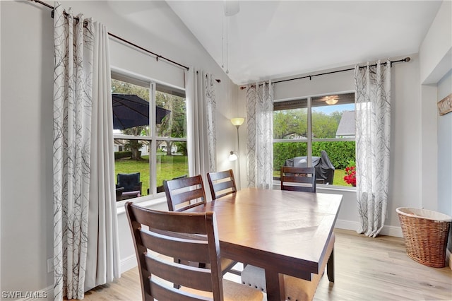 dining area with lofted ceiling and light wood-type flooring