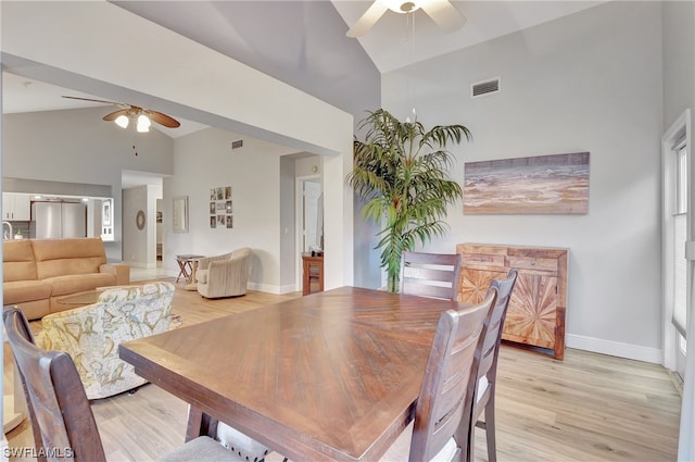 dining space featuring high vaulted ceiling, light hardwood / wood-style floors, and ceiling fan