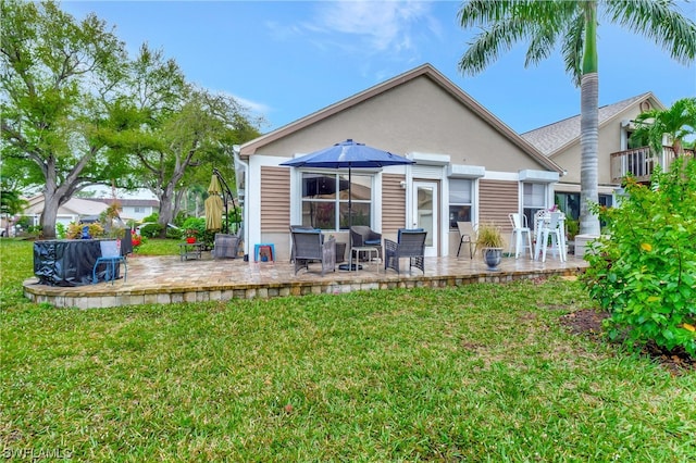 back of property with a yard and a patio area