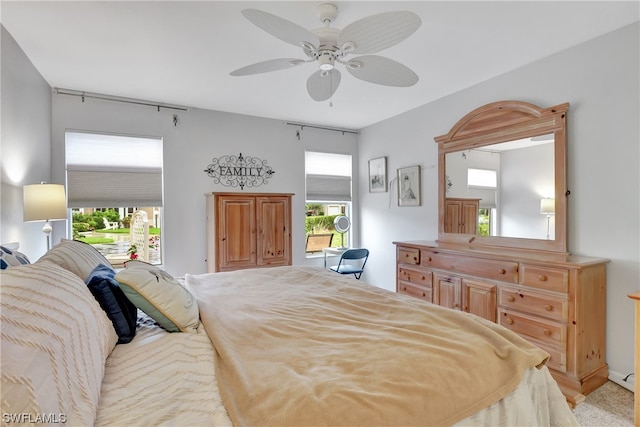 carpeted bedroom featuring multiple windows and ceiling fan