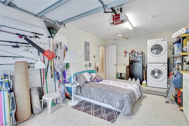 bedroom with black refrigerator, stacked washing maching and dryer, ceiling fan, and sink