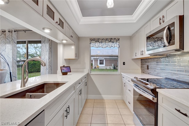 kitchen featuring stainless steel appliances, white cabinets, backsplash, a raised ceiling, and sink