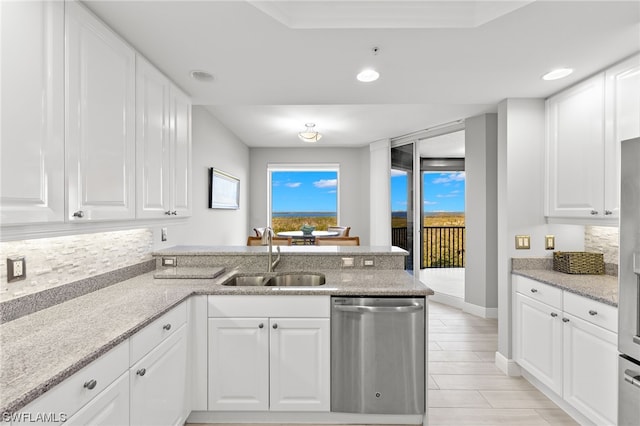 kitchen featuring decorative backsplash, dishwasher, sink, and white cabinets