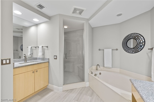 bathroom featuring tile patterned flooring, plus walk in shower, and vanity