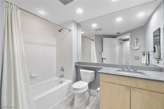 full bathroom with vanity, shower / tub combo with curtain, and toilet