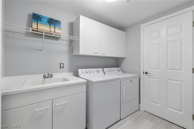 laundry area featuring sink, cabinets, light tile patterned floors, and separate washer and dryer