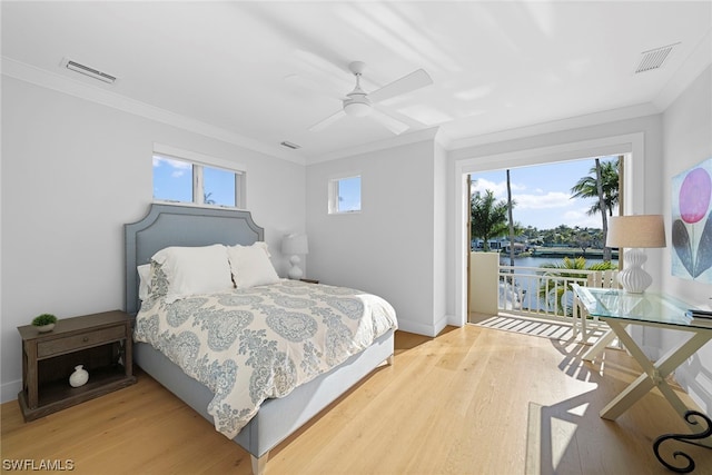 bedroom featuring multiple windows, light hardwood / wood-style floors, ceiling fan, and ornamental molding