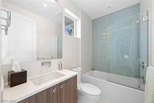 full bathroom featuring toilet, combined bath / shower with glass door, and vanity