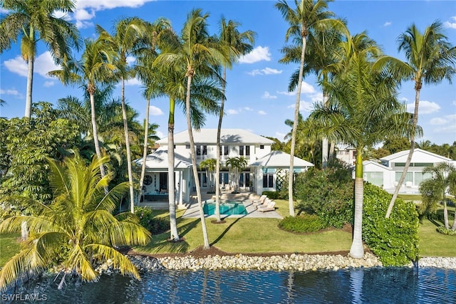 rear view of property with a yard, a patio area, and a water view