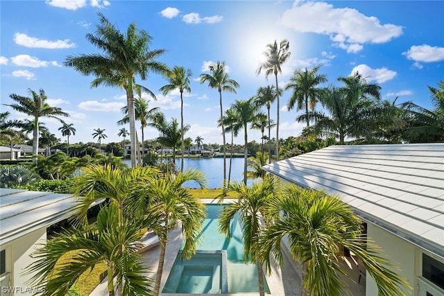 exterior space featuring a pool with hot tub and a water view