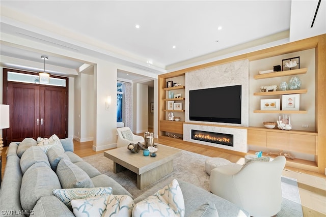 living room with light hardwood / wood-style floors and built in shelves