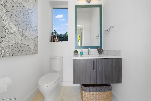 bathroom with toilet, tile floors, and vanity