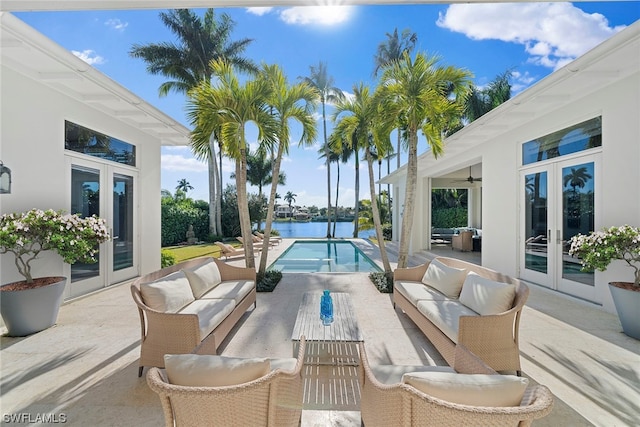 view of patio with outdoor lounge area, french doors, and a water view