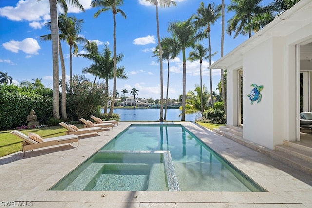 view of pool featuring a patio area, an in ground hot tub, and a water view