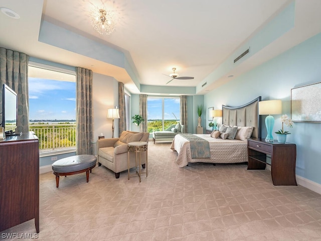 carpeted bedroom featuring ceiling fan with notable chandelier