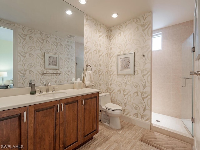 bathroom featuring toilet, vanity, and tiled shower