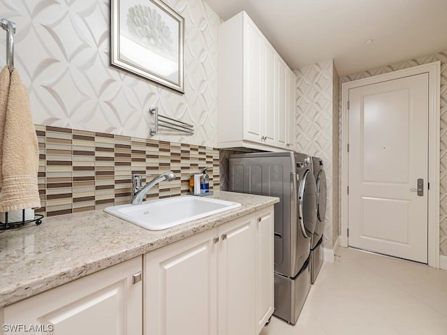 washroom featuring cabinets, sink, washer and dryer, and light tile patterned flooring