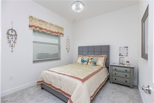 bedroom with a notable chandelier and light carpet