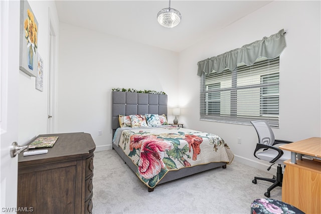 bedroom with light colored carpet and a notable chandelier