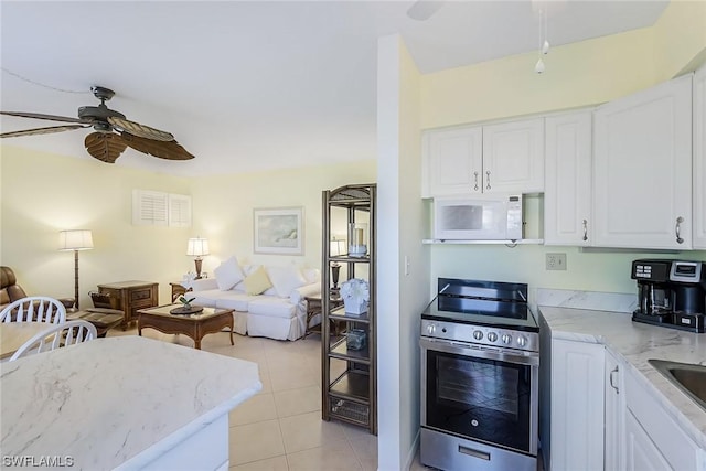 kitchen featuring light stone countertops, white cabinetry, ceiling fan, stainless steel electric range, and light tile patterned flooring