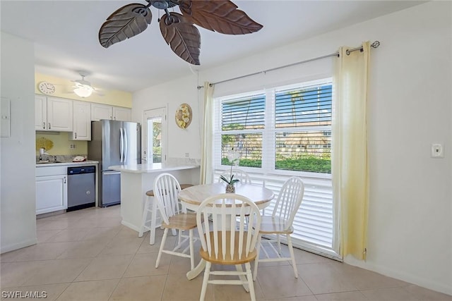 tiled dining space with ceiling fan and sink