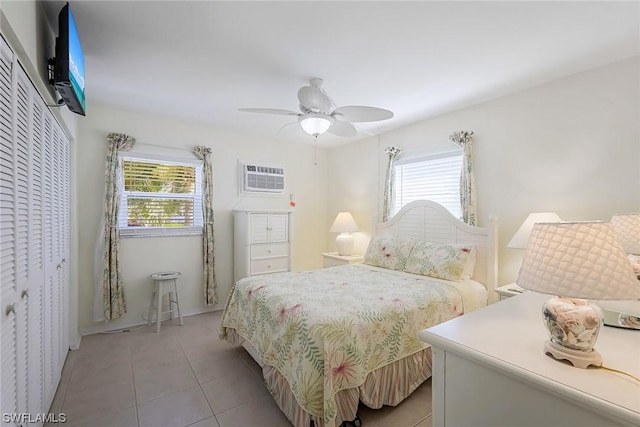 tiled bedroom featuring multiple windows, ceiling fan, and a closet