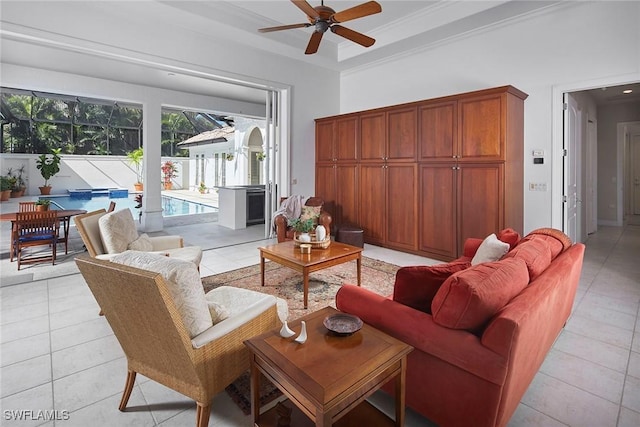 living area with light tile patterned floors, ceiling fan, and a tray ceiling