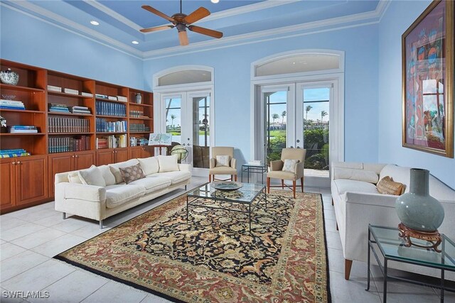 living area with french doors, crown molding, a towering ceiling, and light tile patterned floors