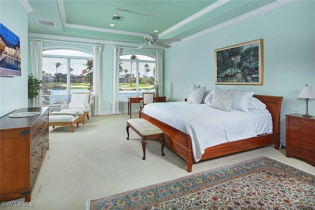 carpeted bedroom featuring ornamental molding, a tray ceiling, and visible vents