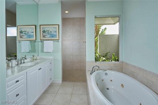 bathroom with tile patterned flooring, vanity, and a tub with jets