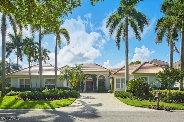 view of front of property featuring decorative driveway and stucco siding