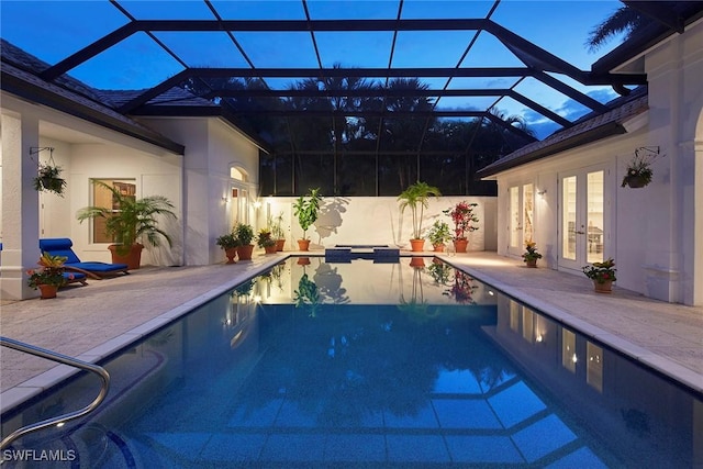 view of swimming pool featuring a patio area, a pool with connected hot tub, glass enclosure, and french doors