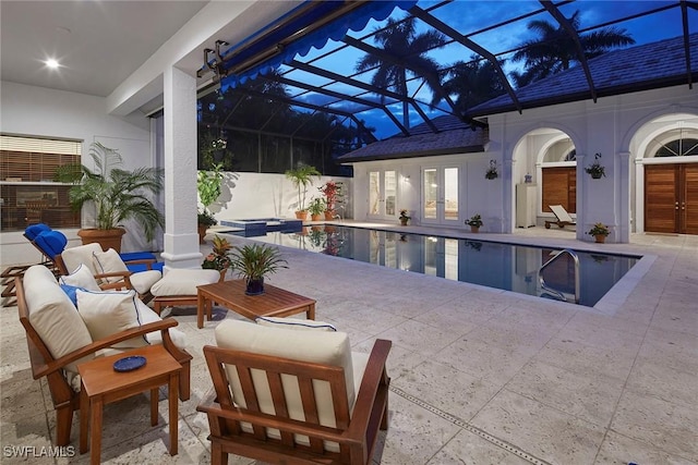 pool featuring a lanai, a patio area, an outdoor hangout area, and french doors