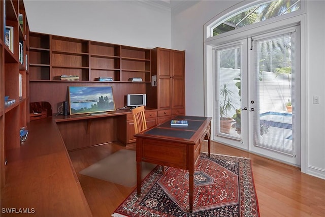 office featuring french doors, baseboards, and light wood finished floors