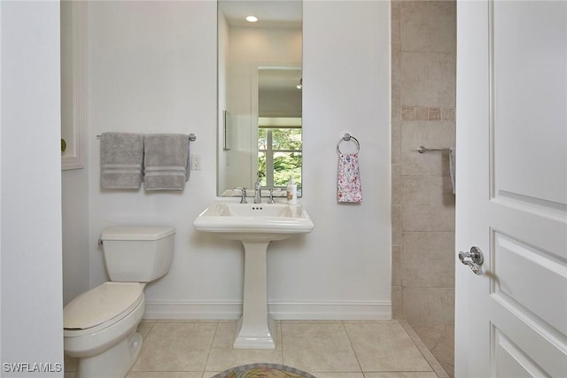 bathroom featuring tile patterned flooring, baseboards, and toilet