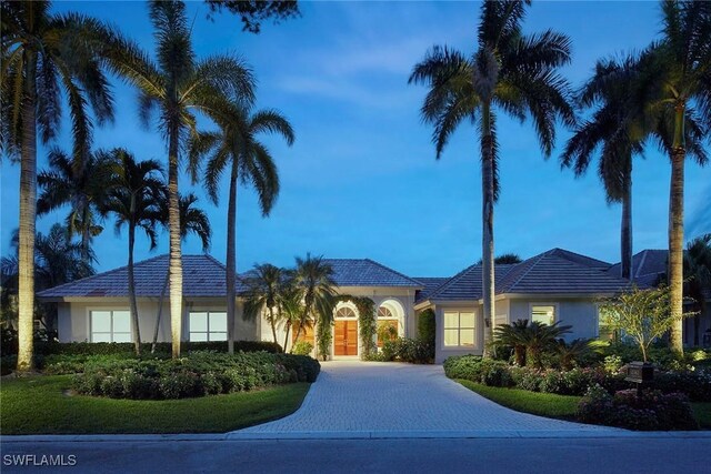 view of front of house with curved driveway and stucco siding